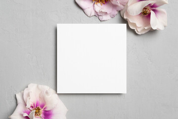 Square paper card mockup with fresh flowers on grey backgroound, copy space for card design