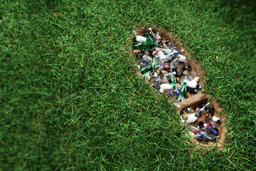 Concept plastic pollution, human footprint in green grass filled with trash, plastic waste, humanity's legacy. 3D rendering, Copy Space