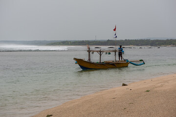 Barca bordeando la playa para acceder al canal que permita evitar el fuerte oleaje para hacer pesca...