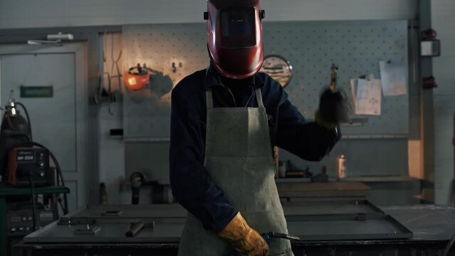  Welder wearing a protective apron wears a welding