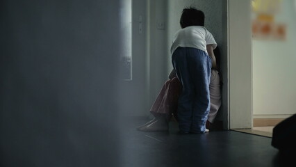 Small brother consoling sister in home corridor. Family taking care of each other during difficult times, childhood depression concept showing sympathy