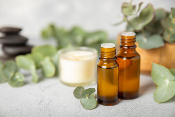 Eucalyptus essential oil in a glass bottle with green eucalyptus leaves on a textured wooden background. Aromatherapy concept. Spa. Natural organic ingredients for cosmetics and body care.Copy space