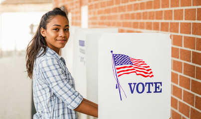 Young African American woman are seen casting his vote at a voting booth during the USA general elections. Concept of diversity, inclusion, and empowerment of african american and young voters in the