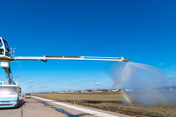 Airport deicing machine perform spraying training for operators. Rainbow on cloud of sprayed deicing fluid.