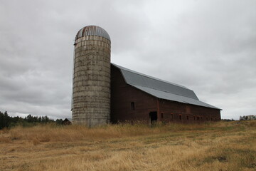 Fototapeta na wymiar photo of old hay barn in clearwater county in idaho with a grain silo attached