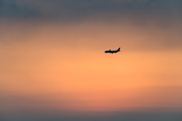 View of the sunset with a flying airplane