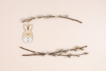 Fototapeta premium Happy Easter concept. Flat lay, top view of Easter eggs, willow plant branches, rabbit on isolated pastel beige background