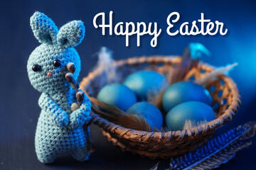 Happy Easter greeting card. Blue Easter eggs in a wicker basket, a blue bunny toy
