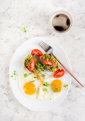 Keto breakfast. Fried eggs and toast with guacamole and tomatoes. Top view, flat lay