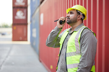 worker or engineer using walkie talkie and talking about work in containers warehouse storage