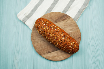 black sliced bread with bran on a blue table. oval dark bread on light texture	