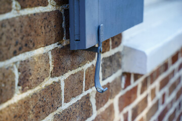 Background of brass window hook. These hooks are not used anymore since people feel inconvenient. Houses are built without hook and latch. Windows are fake and fixed to walls for decoration purpose