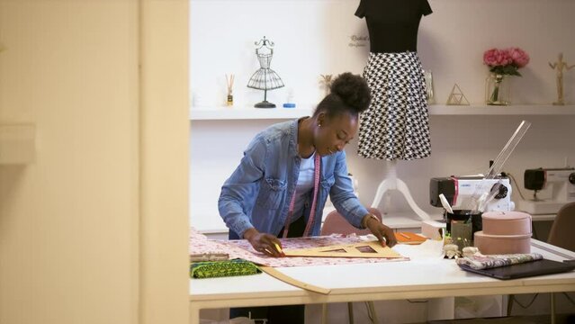Female fashion trailor working on dress diesign in her workshop.