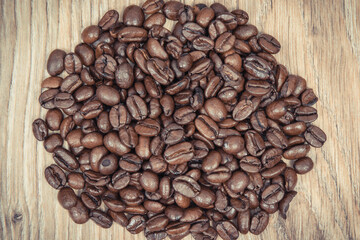 Heap of dark roasted coffee grains in jute bag