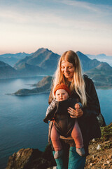Family travel mother hiking with baby carrier healthy lifestyle outdoor family time summer vacations in Norway  mom with child exploring Lofoten islands, Mothers day - 746035011