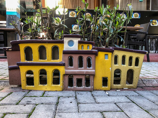 A small toy house in the form of a flower pot on the street in the city of Alanya, Turkey.