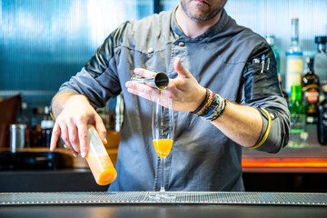 Barman prepara mimosa con champagne y zumo de naranja fresco una mimosa cocktail sobre iuna barra...