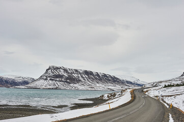 Northern landscapes: A scenic route curving around the snowy mountains of Hvalfjörður fjord.
