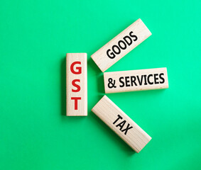 GST - Goods and Services Tax symbol. Concept word GST on wooden blocks. Beautiful green background. Business and GST concept. Copy space.