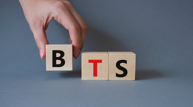 BTS symbol. Wooden cubes with word BTS. Businessman hand Beautiful grey background. BTS concept. Copy space.