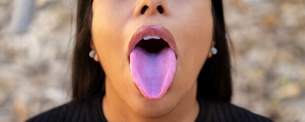 Sexy latin young woman with bright pink sensual lips showing her beautiful healthy long pink tongue...