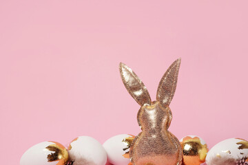 Easter card. golden Easter bunny and eggs with glitter on pink background