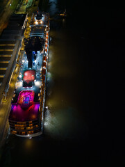 Aerial view above colorful top deck lights with swimming pool on a cruise ship before departure in...