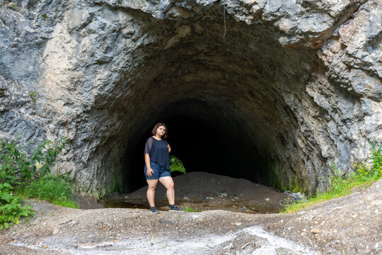 A traveler stands at the entrance to a large cave