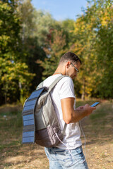 Man with backpack charging phone from solar panel