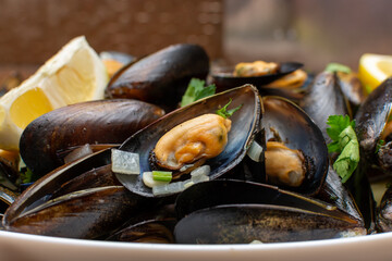 Cooked mussels in a shell with herbs and lemon