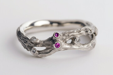 Silver or white gold cocktail ring with diamonds and pink sapphires closeup. Precious gems and metals, natural gemstone jewelry