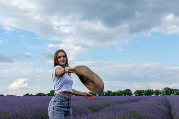 Young woman throwing hat in lavender field