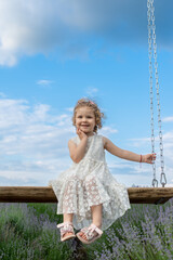 Little girl riding on a swing in lavender