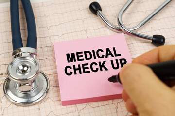 On the cardiograms there is a stethoscope and a sticker with the inscription - MEDICAL CHECK UP