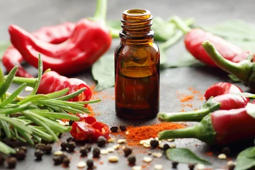 Foto op Plexiglas Red chili pepper oil, tincture, extract or vinegar with fresh vegetables and leaves on black table, closeup, copy space, organic spicy food, hair and body healthy care concept © teatian