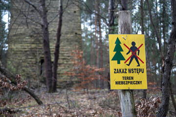 Ogrodzenie i tabliczka ostrzegająca o wejściu na niebezpieczny teren w lesie - obrazy, fototapety, plakaty