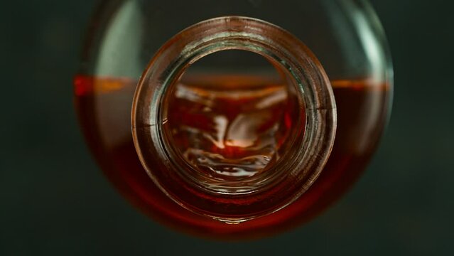 Super Slow Motion of Pouring Whisky from Bottle into Glass. Filmed on High Speed Cinema Camera, 1000 fps, Placed on High Speed Cine Bot. Camera Follows the Stream of Liquid.
