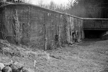 Poniemiecki bunkier - widoczna ściana z wejściem i widoczną strzelnicą na ciężki karabin maszynowy, który je osłaniał - obrazy, fototapety, plakaty