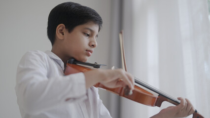 boy playing violin at home