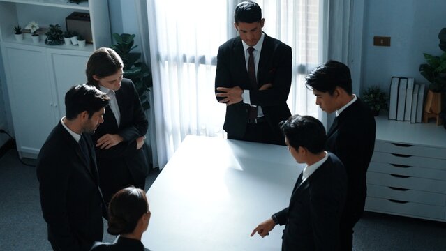 Top view of project manager looking at meeting table surrounded by diverse business people brainstorm and planning strategy. Group of smart people discussing and solve business problems. Directorate.
