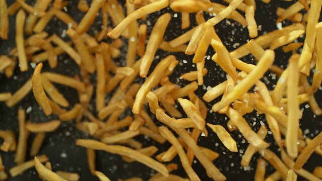 Super Slow Motion of Flying French Fries up in the Air on Black Background. Filmed on High Speed Cinema Camera, 1000 fps. Speed Ramp Effect.