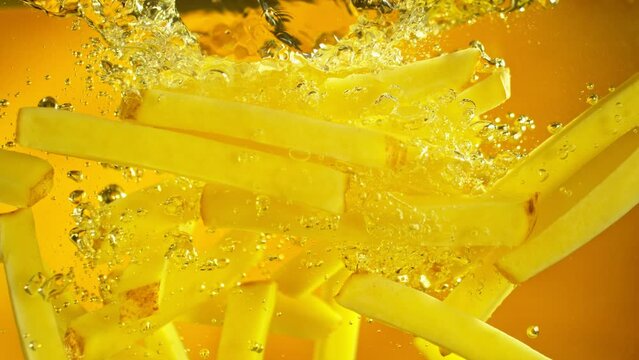 Super Slow Motion of Falling French Fries into Oil. Underwater Composition of Splashing Potatoes Fries. Filmed on High Speed Cinema Camera, 1000 fps. Speed Ramp Effect.