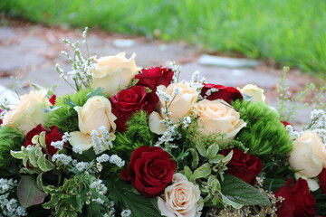Rosen der Trauer im Gesteck nach Beerdigung auf dem Friedhof