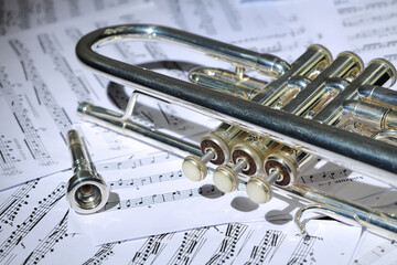 A view of the musical instrument which is the trumpet against the background of the sheet music