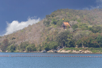 View of Thai temple at Ubonrat Dam during the day with sunlight and clear weather.