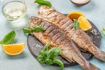 delicious grilled seabass fish with lemon and spices with white wine. banner, menu, recipe place for text, top view