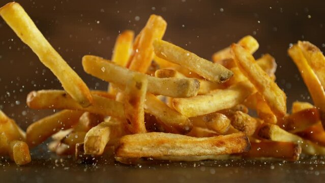 Super Slow Motion of Flying French Fries. Filmed on High Speed Cinema Camera, 1000fps, Placed on High Speed Cine Bot. Camera in Motion, Following Objects. Speed Ramp Effect.