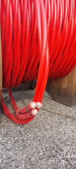 Detail of cable drum also called Electrical conductor reel with red cables to high-voltage without...