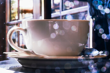 Cup of hot drink with against window with bokeh background