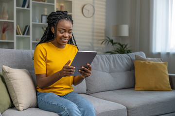Happy young african american woman with tablet at home